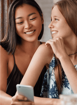 Two Girls Are Talking and Seeing in the Mobile Screen - Mortie